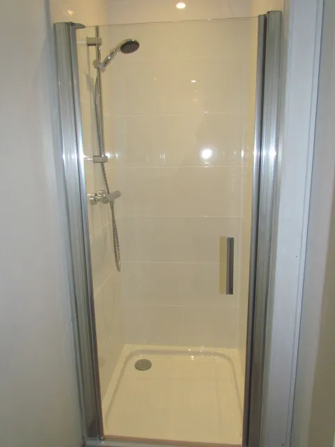 Nouvelle cabine de douche avec porte vitrée après rénovation – IDGS Constructions, région de Vilvorde