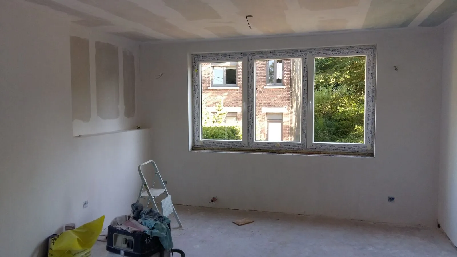 Séjour aux murs nus et poncés avant la rénovation à Rixensart